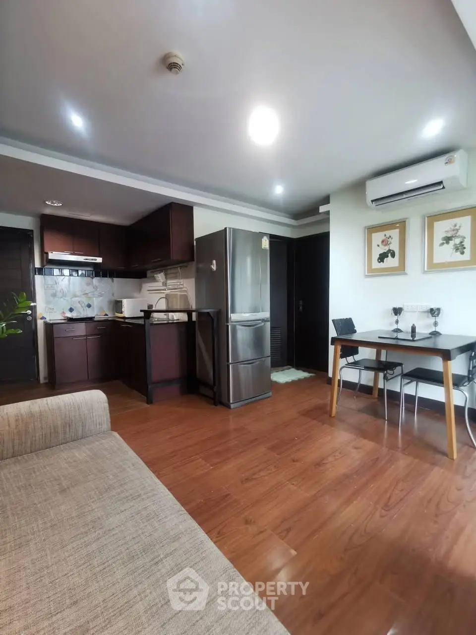 Modern kitchen and dining area with wooden flooring and stainless steel appliances