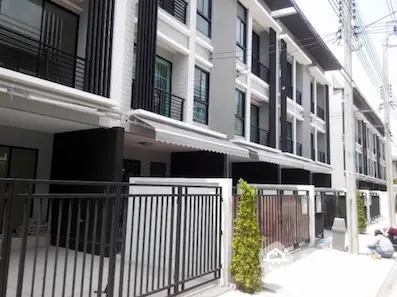 Elegant townhouses with modern black and white facades, offering a secure gated community living experience in a prime location.