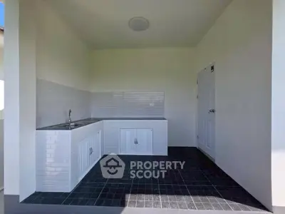 Modern outdoor kitchen with sleek white cabinetry and tiled backsplash