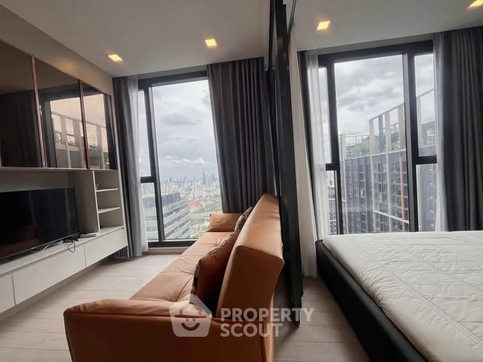 Modern high-rise apartment with stunning city view, featuring a cozy living area and sleek bedroom design.