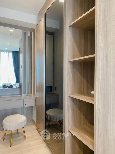 Modern bedroom with stylish wooden wardrobe and elegant stool, featuring ample natural light.