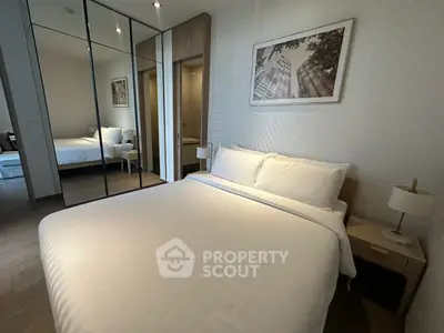Modern bedroom with mirrored closet and elegant decor in a stylish apartment.