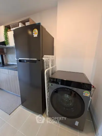 Modern kitchen with sleek appliances including fridge and washing machine