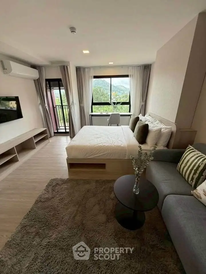 Modern bedroom with scenic view, cozy seating, and stylish decor in a high-rise apartment.