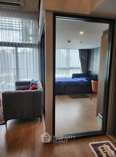 Modern apartment interior with glass partition, featuring a cozy bedroom and stylish living area.