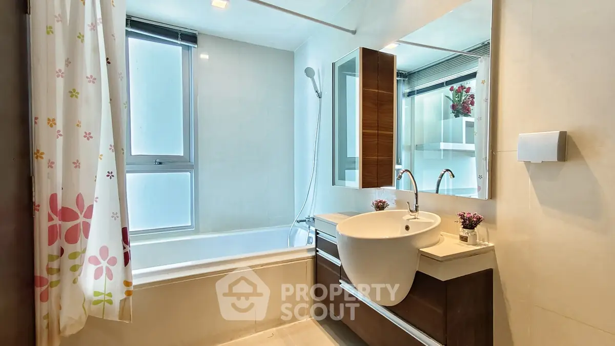 Modern bathroom with bathtub and stylish vanity in a bright, contemporary apartment.