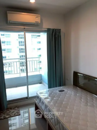 Cozy bedroom with balcony access and air conditioning in modern apartment.