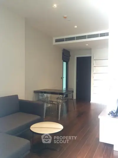 Modern living room with sleek furniture and wooden flooring in a stylish apartment.