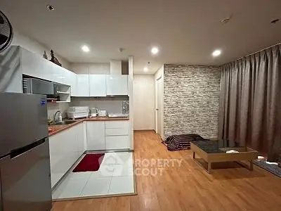 Modern open-layout kitchen and living area with stylish decor and wooden flooring.