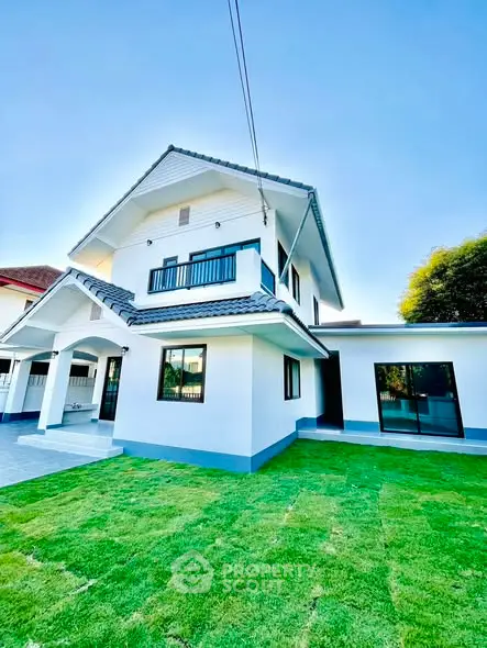 Charming two-story house with lush green lawn and modern exterior design.