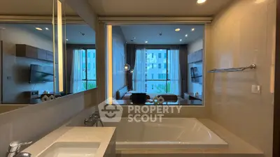Luxurious bathroom with modern bathtub and view into stylish living room