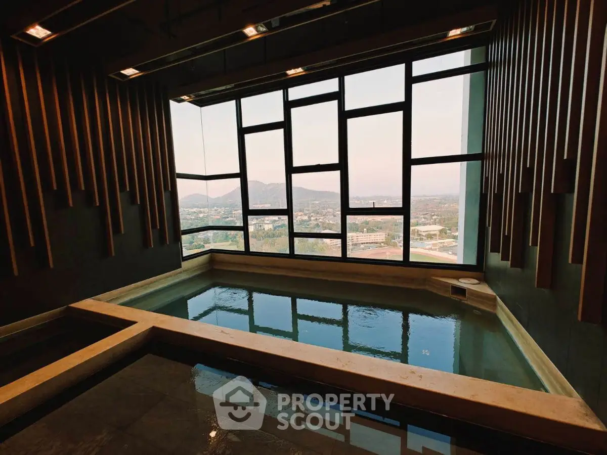 Luxurious indoor pool with panoramic city view and modern design.