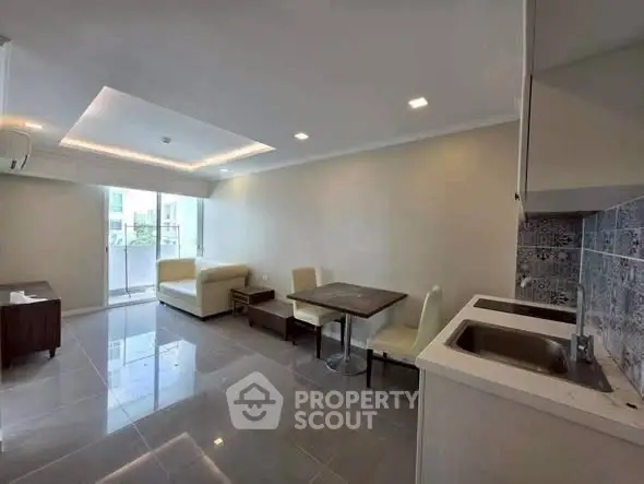 Modern living room with open kitchen and sleek tile flooring