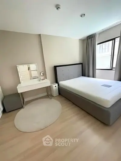 Modern minimalist bedroom with stylish furniture and large window for natural light.