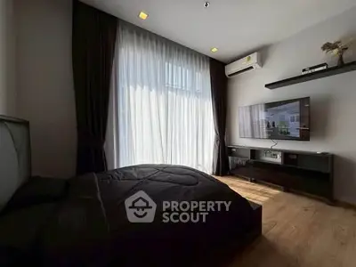 Modern bedroom with large window, elegant curtains, and wall-mounted TV.