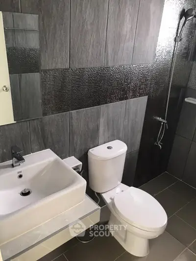 Modern bathroom with sleek gray tiles and contemporary fixtures.