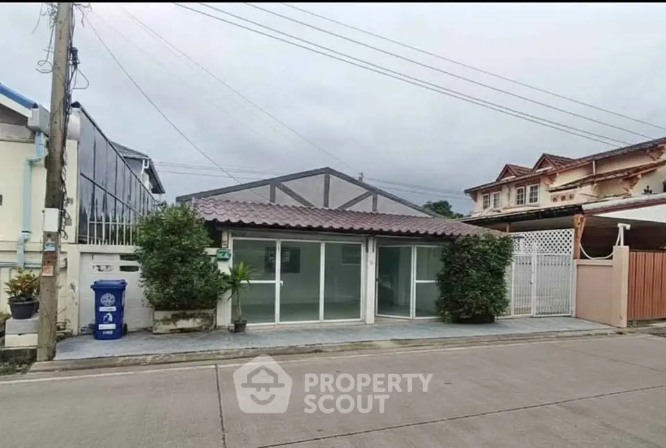 Charming single-story home with modern facade and lush greenery in a quiet neighborhood.