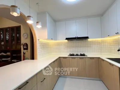 Modern kitchen with sleek cabinetry and gas stove in a stylish home.