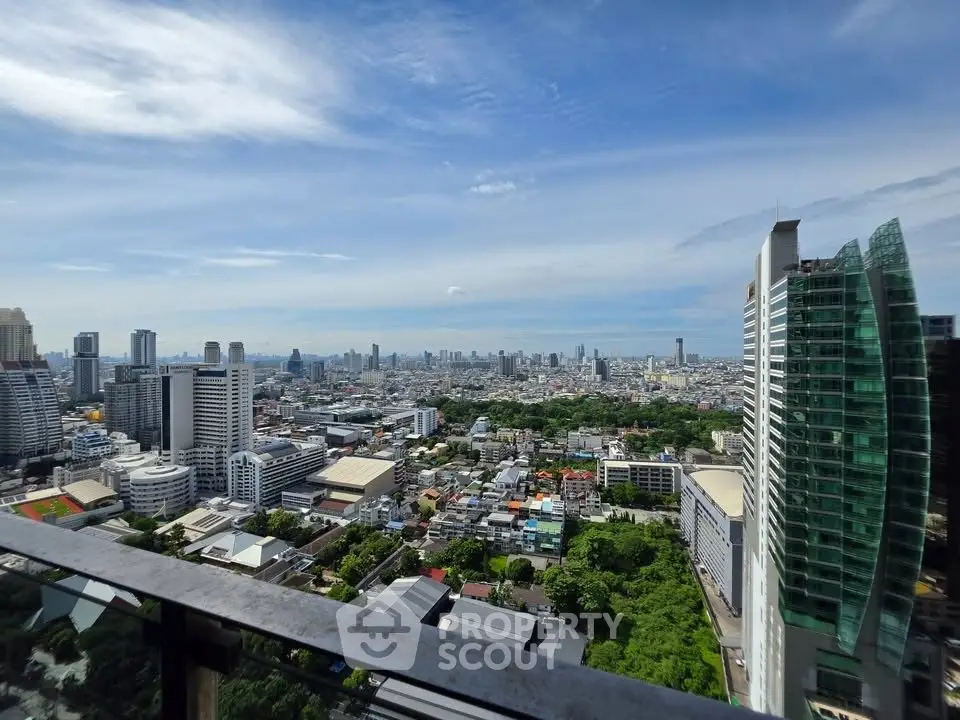Stunning cityscape view from a high-rise balcony showcasing urban skyline and lush greenery.
