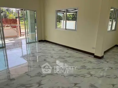 Spacious interior with marble flooring and large windows opening to garden view