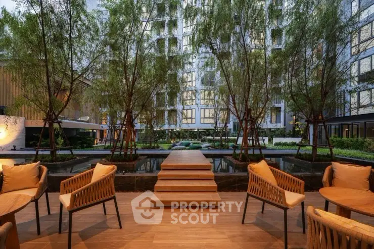 Luxurious outdoor seating area with modern design and lush greenery in a high-end residential complex.