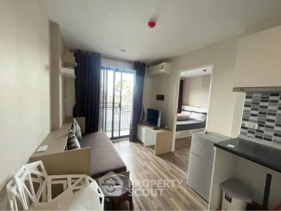 Modern open-plan living room with balcony access in stylish apartment