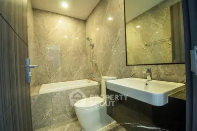 Luxurious marble bathroom with modern fixtures and bathtub in elegant real estate property.