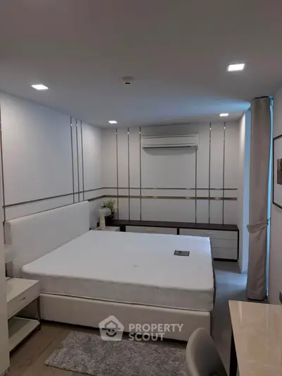 Modern bedroom with stylish decor and air conditioning in a contemporary apartment.