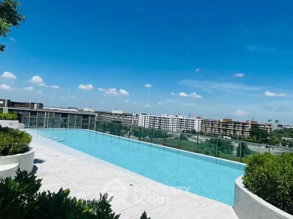 Luxurious rooftop pool with stunning city views and clear blue skies.