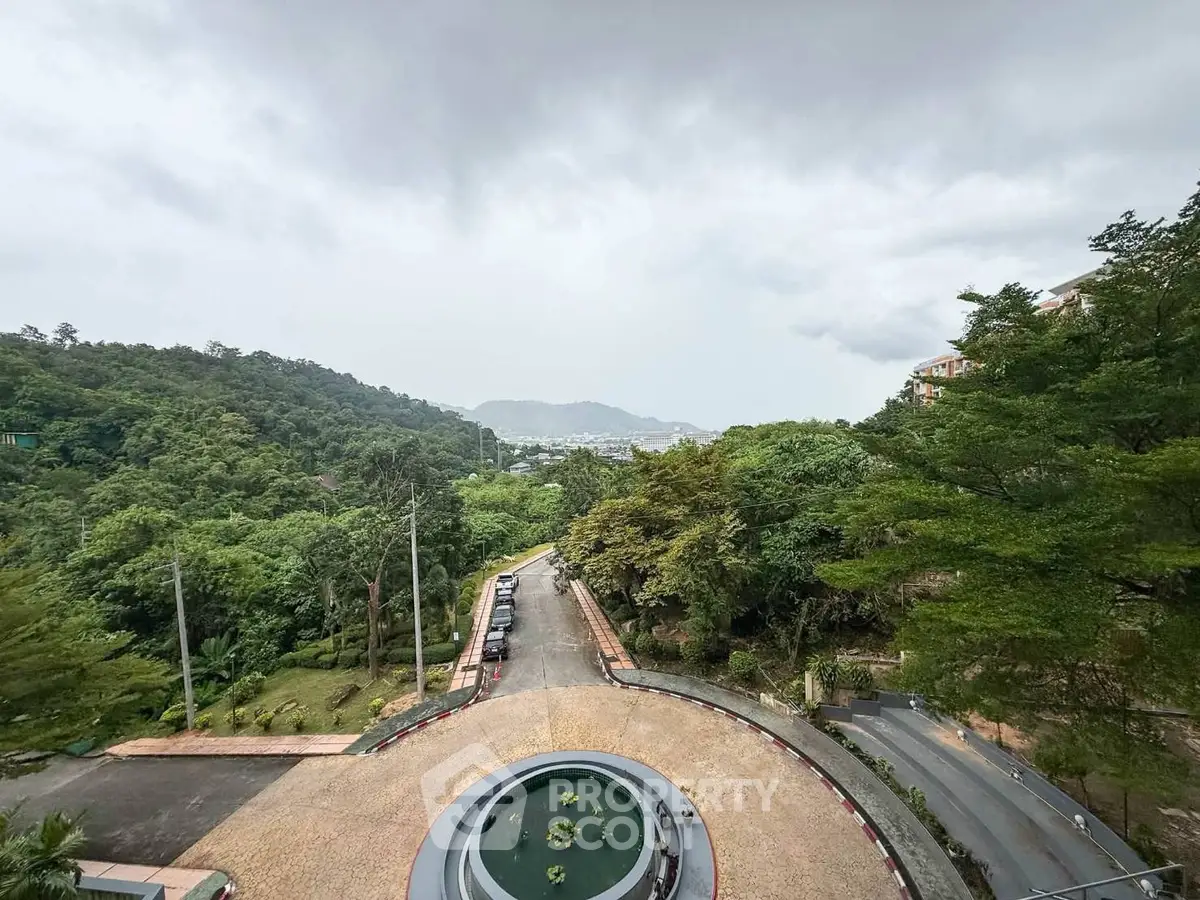 Stunning panoramic view from a high vantage point overlooking lush greenery and distant mountains.