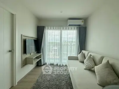 Modern living room with large window and stylish decor in a high-rise apartment.