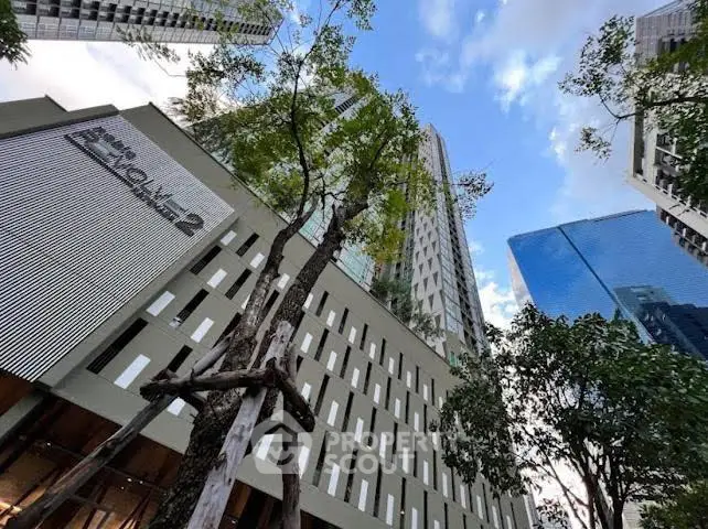 Stunning modern high-rise building with lush greenery and blue sky backdrop.