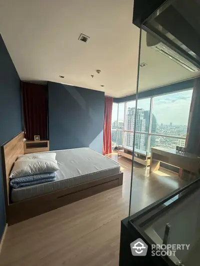 Modern bedroom with city view and large windows in high-rise apartment