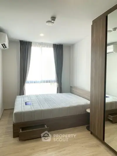 Modern bedroom with large window and sleek wooden furniture, perfect for comfortable living.