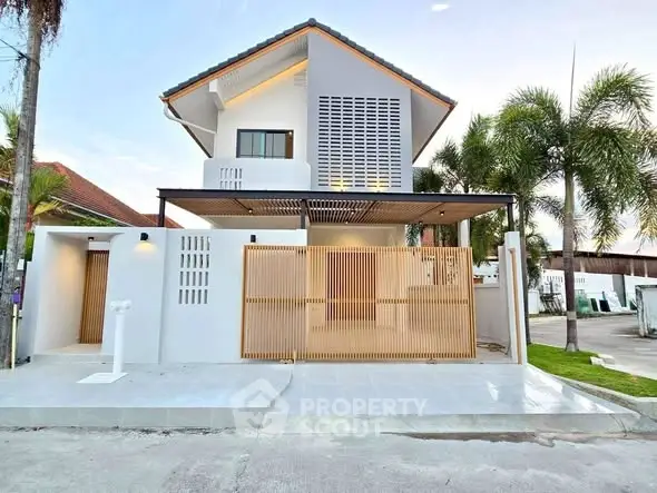 Modern two-story house with sleek design and palm trees in a serene neighborhood.