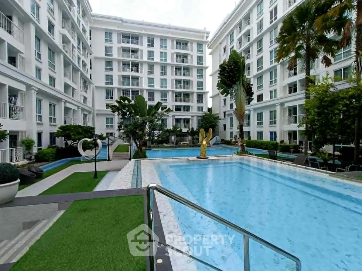 Luxurious condominium with stunning pool and lush greenery in a modern residential complex.