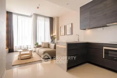 Modern open-layout living room and kitchen with sleek design and natural light.
