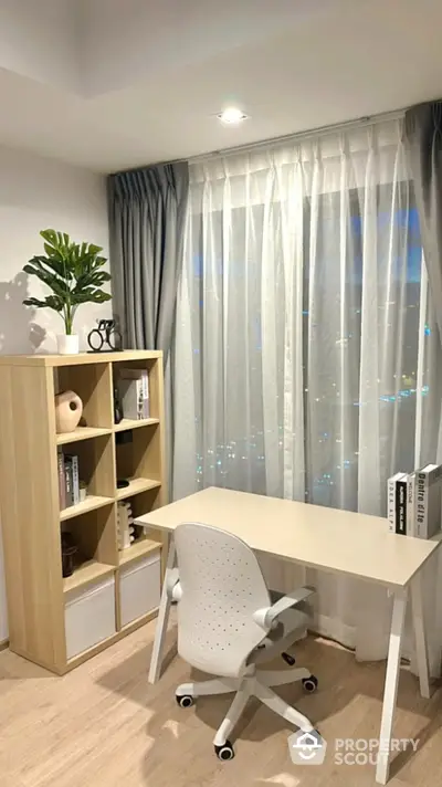 Modern study room with stylish desk and shelving unit, featuring a large window with city view.