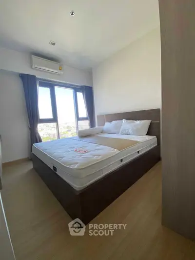 Modern bedroom with large windows and natural light in a stylish apartment.