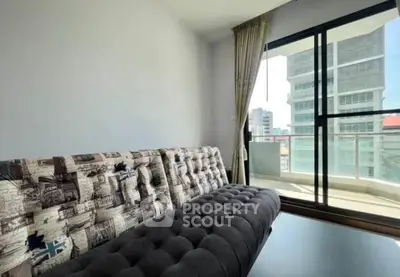 Modern living room with stylish sofa and large balcony window offering city views.