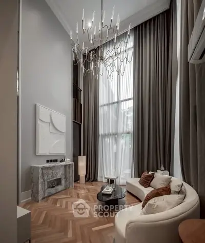 Luxurious high-ceiling living room with elegant chandelier and modern decor