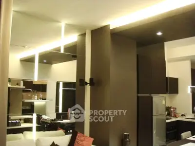 Modern living room with sleek kitchen and stylish lighting in open layout apartment.