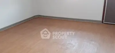 Spacious empty room with wooden flooring and neutral walls, ideal for customization.