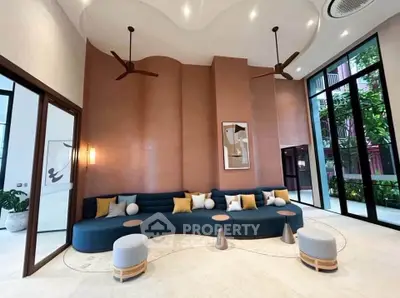 Luxurious modern living room with high ceilings, stylish seating, and elegant decor in a contemporary apartment.