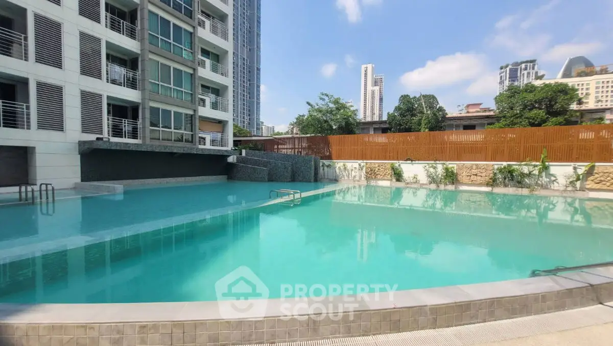 Luxurious residential building with a stunning outdoor pool and city views.