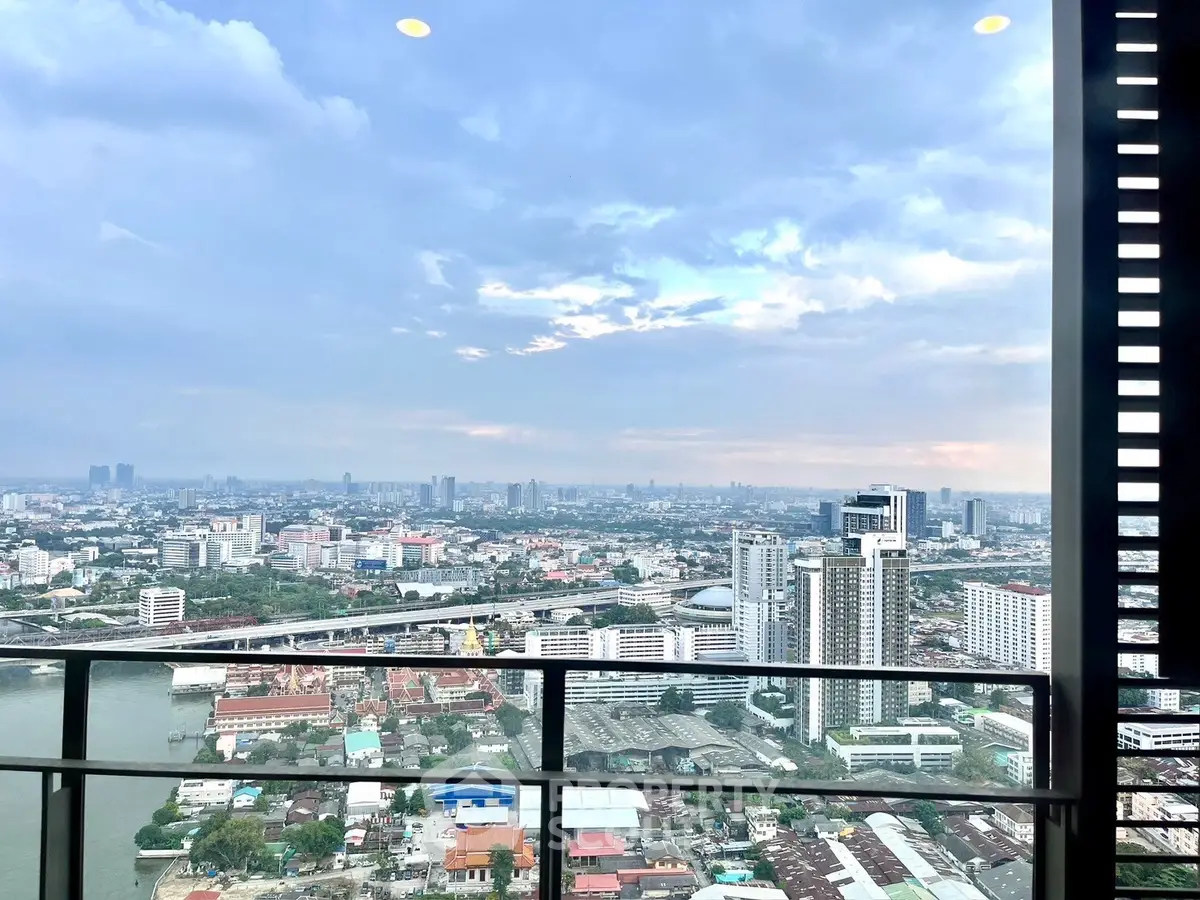 Stunning cityscape view from high-rise balcony with expansive skyline and river below.