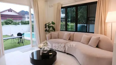 Stylish living room with curved sofa and garden view, perfect for relaxation.
