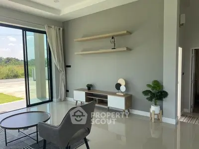 Modern living room with sleek furniture and large sliding glass doors opening to a garden view.