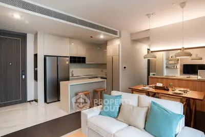 Modern open-plan living room and kitchen with stylish decor and ample natural light.