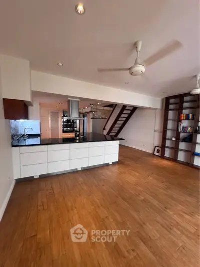Spacious open-plan living room with modern kitchen and wooden flooring